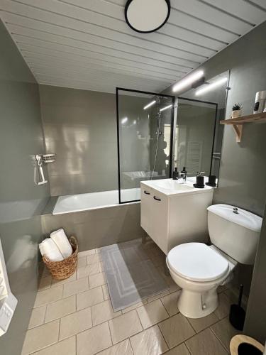 a bathroom with a toilet and a sink and a tub at Charmant studio avec terrasse in Fécamp
