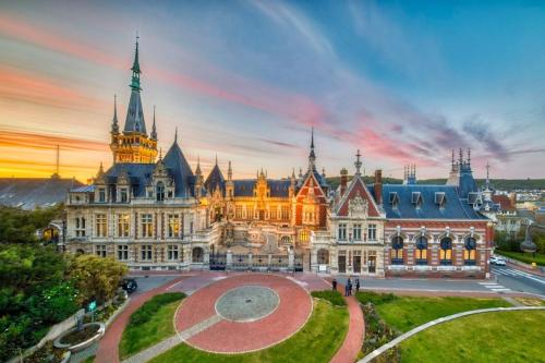 a large building with a sunset in the background at Charmant studio avec terrasse in Fécamp
