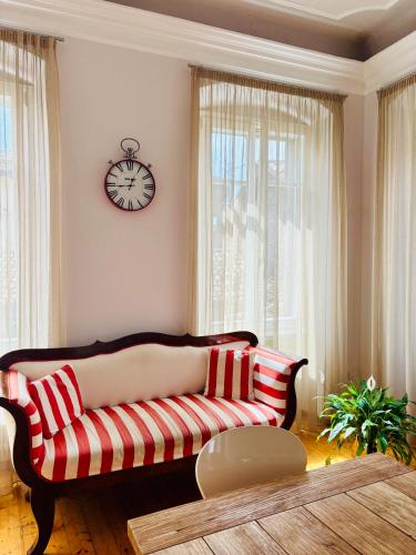 un salon avec un canapé et une horloge au mur dans l'établissement Al Cavour 34, à Trente