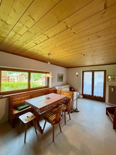 uma sala de jantar com uma mesa e cadeiras e uma cama em Appartamento Sass Aut em Soraga