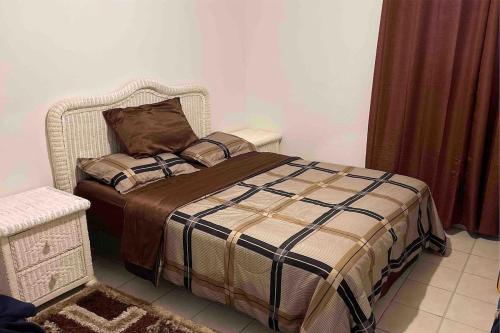a bedroom with a bed with a blanket and a chair at Lovely 2 bedroom condo with pool in Marigot