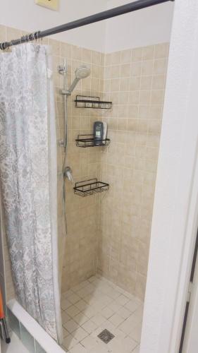 a bathroom with a shower with a shower curtain at Lovely 2 bedroom condo with pool in Marigot