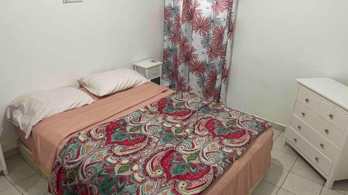 a small bedroom with a bed with a colorful blanket at Lovely 2 bedroom condo with pool in Marigot