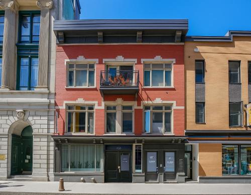 a red brick building with a balcony on a street at Deluxe Estate // Two in One Downtown Québec City in Quebec City