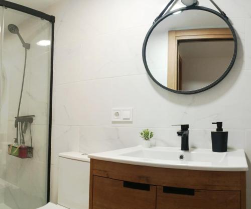 een badkamer met een wastafel en een spiegel bij Casa Bea in Puertomingalvo