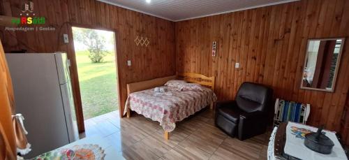 Ένα ή περισσότερα κρεβάτια σε δωμάτιο στο Chalézinho Bons Ventos Campestre no Sitio com Churrasqueira WI-FI a 6km da Estrada do Mar 7km Parque de Rodeio II 8,1Km Prefeitura II 7,2Km UFRGS Litoral II Taxi Fácil II Tranquilidade 12km Praias Tramandai