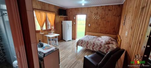 una piccola camera con letto e frigorifero di Chalézinho Bons Ventos Campestre no Sitio com Churrasqueira WI-FI a 6km da Estrada do Mar 7km Parque de Rodeio II 8,1Km Prefeitura II 7,2Km UFRGS Litoral II Taxi Fácil II Tranquilidade 12km Praias Tramandai a Osório