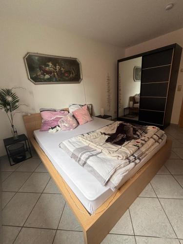 a bedroom with a bed with white sheets and pink pillows at FEWO Caro in Nordhausen