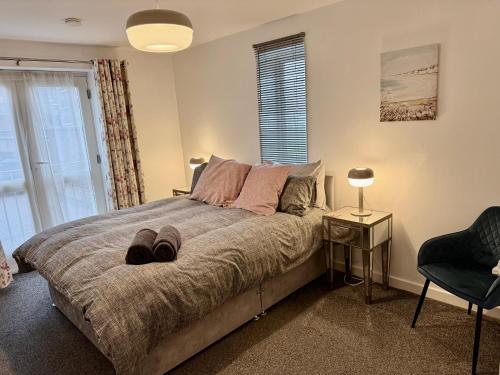 a bedroom with a bed with a chair and a window at Superb 2 bed 2 bathroom free parking in Derby