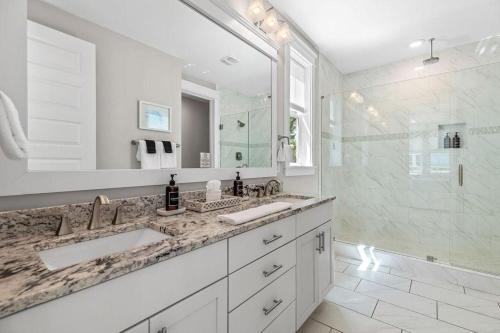 a bathroom with two sinks and a large mirror at Flor Da Li by the Sea in Inlet Beach
