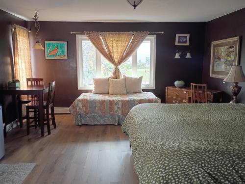 a bedroom with two beds and a table and a window at Biking, Hiking, Getaways & Relaxation Retreats - Visit the VT Chocolate Room - Large & Cozy, Homey, Jacuzzi Tub, Scenic Walks in Colchester