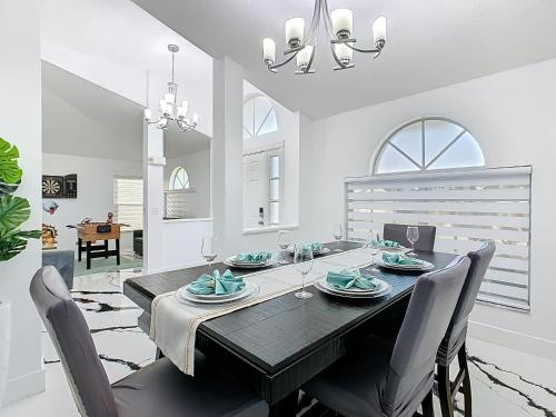 a dining room with a black table and chairs at Casita mi Encanto a Cozy & Spacious House, 4-bedroom 3-Bath & pool in Kissimmee