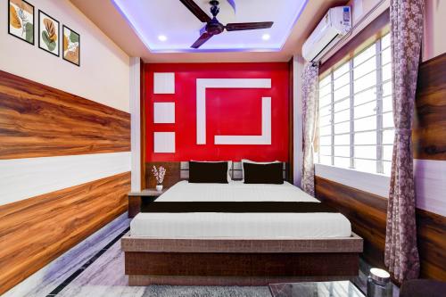 Un dormitorio con una cama con una pared roja. en Super Collection O New Jalpaiguri Railway Station Formerly Prince Lodge, en Siliguri