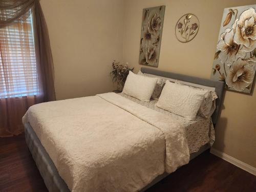 a bedroom with a bed with white sheets and a window at Laribond's Place Houston Texas in Houston