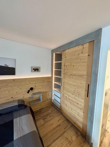 a room with a closet with a wooden door at Fiore delle Alpi in Bellamonte