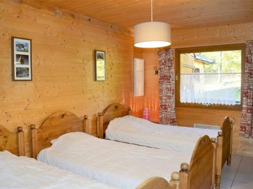 two beds in a room with wooden walls at Grand Appartement Confortable 10/12 Pers, Terrasse, Parking - FR-1-267-250 in Villarembert