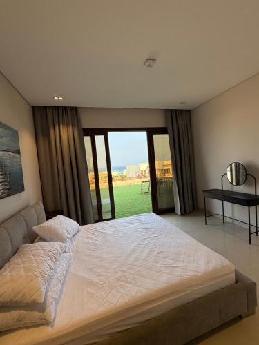 アズ・シーファーにあるVilla La Mer Sifahの大きなベッドと窓のある寝室