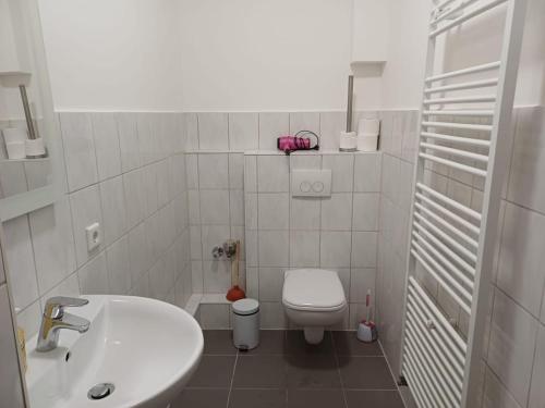 ein weißes Badezimmer mit Waschbecken und Toilette in der Unterkunft Wohnung in Köln 3B in Köln