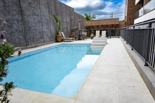 een zwembad met blauw water in een gebouw bij Flat Portal Premium Vinhedo in Vinhedo