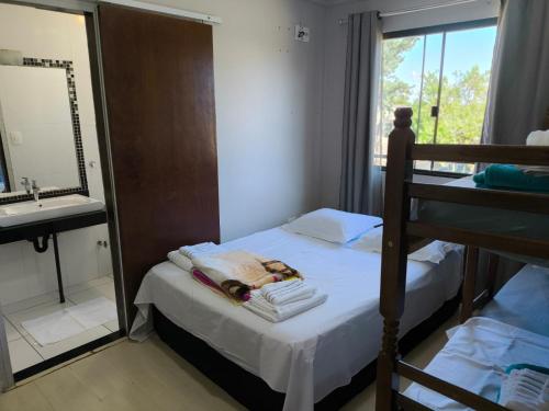 a bedroom with a bunk bed with a mirror and a sink at Lindo espaço de lazer in Cascavel