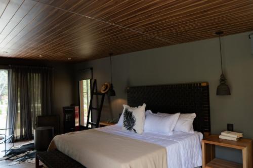 a bedroom with a large bed with a wooden ceiling at Lun Lodges in Ciudad Lujan de Cuyo