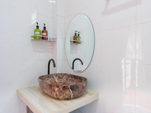 ein Badezimmer mit einem Steinwaschbecken und einem Spiegel in der Unterkunft Vang Vieng Ruby Villa Hotel in Vang Vieng