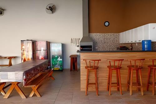 サンタ・フェ・ド・スルにあるRubi casa de temporada com piscina e área gourmetのキッチン(テーブル、椅子、カウンター付)