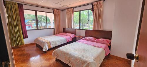 a bedroom with two beds and a window at Casa del Pino in Popayan
