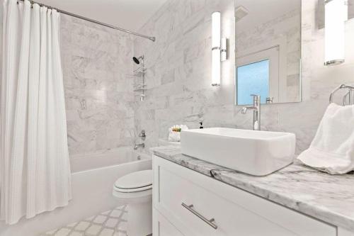 a white bathroom with a sink and a tub and a toilet at Seaside Retreat in Santa Rosa Beach