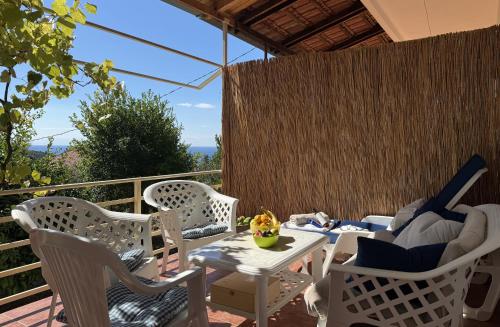 a patio with white chairs and a table with at Summer house Kruce in Kruče