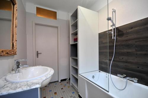 a white bathroom with a sink and a shower at Gîte du Soleil - close to Europa-Park in Grussenheim
