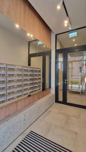 a lobby with a large glass door and a room at Apartament Podniebny z Windą in Kluczbork