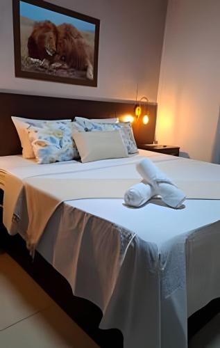 a bed with a white towel on top of it at Casa confortável com piscina e área para churrasco in Sao Jose do Rio Preto