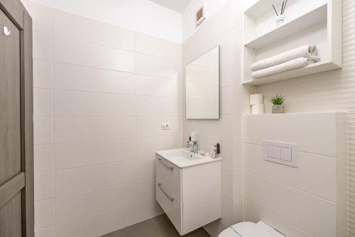a white bathroom with a toilet and a sink at Apartamente Arad Premium in Arad