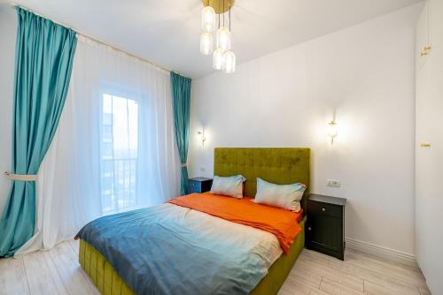 a bedroom with a bed with blue curtains and a window at Apartamente Arad Premium in Arad