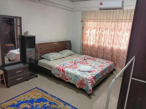 een slaapkamer met een bed, een ladekast en een spiegel bij Asyun Homestay 1 Double Storey House Sg Buloh Town in Sungai Buluh