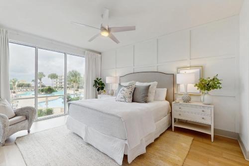ein weißes Schlafzimmer mit einem Bett und einem Fenster in der Unterkunft High Pointe 2221 in Inlet Beach