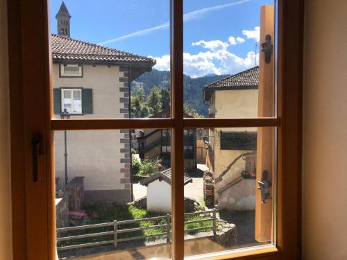 une fenêtre ouverte avec vue sur la ville dans l'établissement Ca' Stella, à Castello-Molina di Fiemme