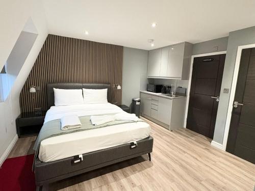 a bedroom with a large bed and a kitchen at Fonthill Aparts in London