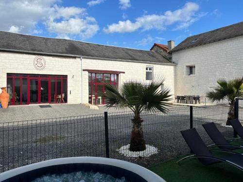 a building with a palm tree in front of it at maison chaleureuse ,avec piscine, spa, Futuroscope in Jaunay-Marigny