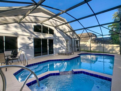an indoor swimming pool with a glass roof at Casita mi Encanto a Cozy & Spacious House, 4-bedroom 3-Bath & pool in Kissimmee