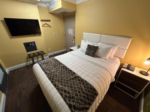 a bedroom with a large bed and a flat screen tv at Hotel Richland LES in New York