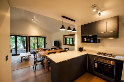 eine offene Küche und ein Esszimmer mit einem Esstisch in der Unterkunft Cabañas Parque Futangue in Lago Ranco