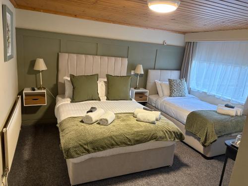 a bedroom with two beds with towels on them at The Boutique Bungalow in Bundoran