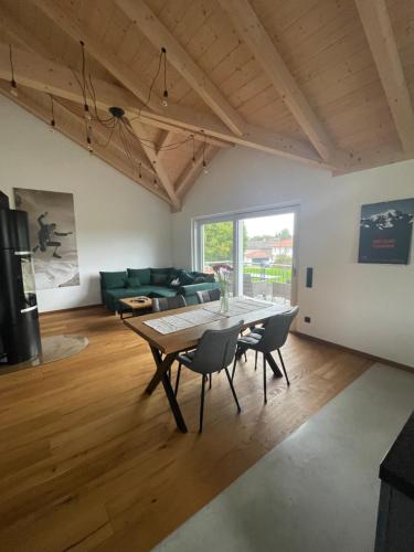 a living room with a table and chairs at Grüne Gams - Neubau Designwohnung mit 2 Balkonen in Breitbrunn am Chiemsee