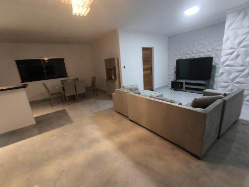 a living room with a couch and a flat screen tv at Varanda das araras in Manaus