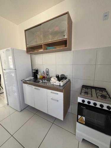 a small kitchen with a stove and a refrigerator at Casa Delta 187 in Parnaíba