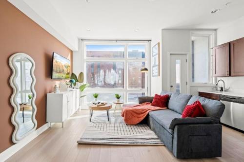 een woonkamer met een bank en een keuken bij Modern 4BR City Escape Steps to MET & Subway Rooftop View in Philadelphia