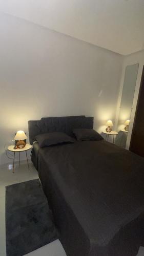 a bedroom with a bed and a table with two lamps at Apartamento com ótima localização! in Belém