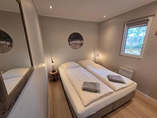 ein kleines Schlafzimmer mit zwei Betten und einem Fenster in der Unterkunft Natuurhuisje Hellendoorn in Haarle